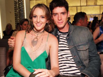 Eleanor Lambert is wearing a green dress whereas, her boyfriend is wearing a denim jacket.